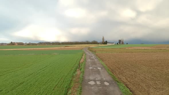 Cinematic drone shot of a field at golden hour during stormy weather alt