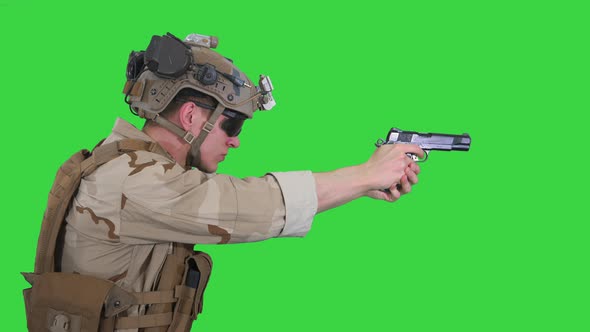 Soldier Aiming and Shooting with a Pistol on a Green Screen, Chroma Key. alt