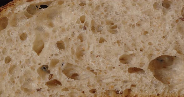 Bread With Flax Seeds, Slice. Rotation On A Black Background. alt