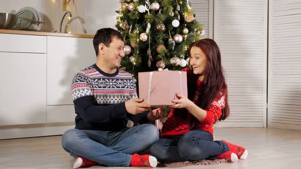 Wife Gets Husband New Year Gift Sitting on Kitchen Floor alt