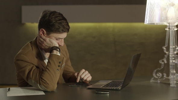 Tired Businessman Uses His Mobile Phone. alt