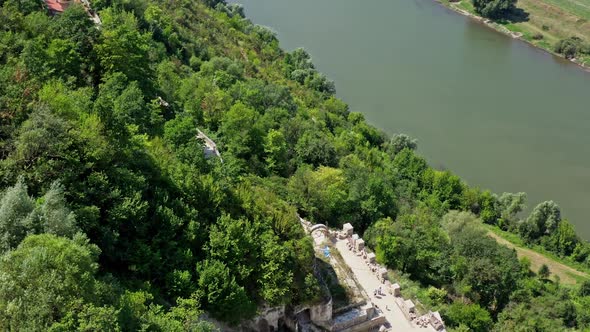 Aerial view on the tower of the castle located on a top of a hill. Beautiful river flows below. alt