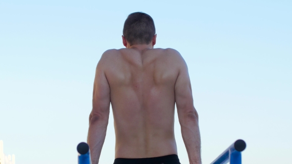 Athletic Man Doing Push-ups On The Bars alt