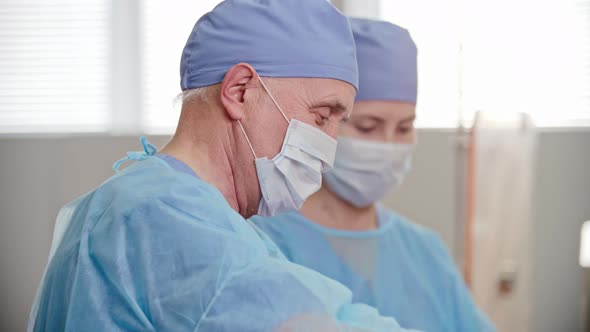 Senior Surgeon Assisted by Nurse alt