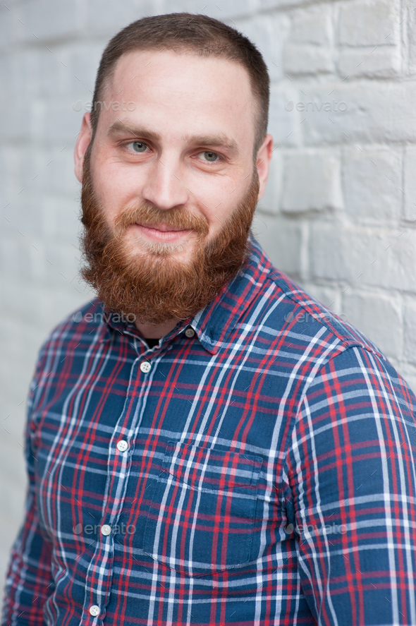 portrait of a young bearded man in a flannel shirt