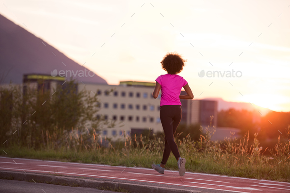 a young African American woman jogging outdoors - Stock Photo - Images