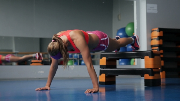 Gorgeous Blonde Woman Warming up and Doing Some Push Ups at the Gym