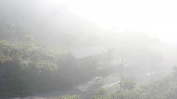 Spooky view of a wooden house through the fog alt