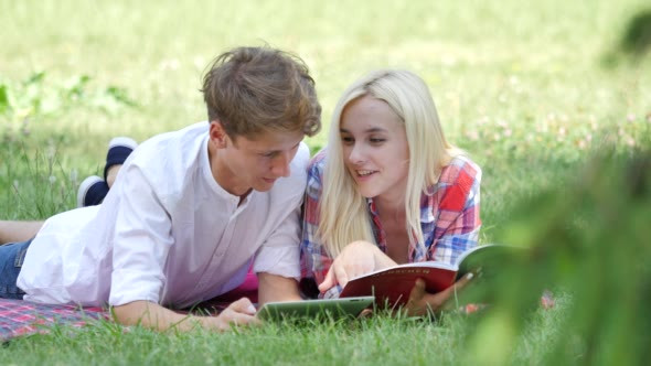 Couple Students Boy and Girl Lying on a Lawn alt