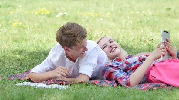 Young Couple Lying on a Grass Reading Students alt