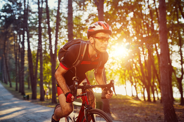 Young man are cycling road bike in the evening Stock Photo by arthurhidden