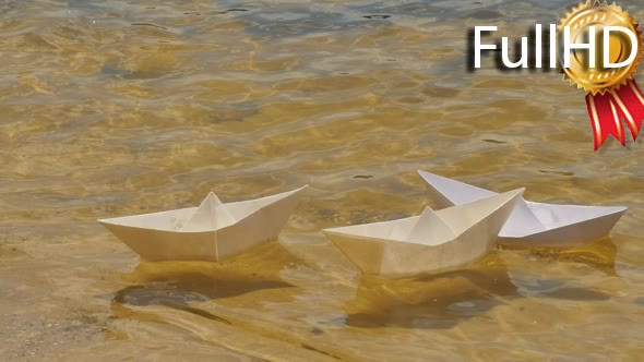 Three White Paper Ships Are Floating by Water alt