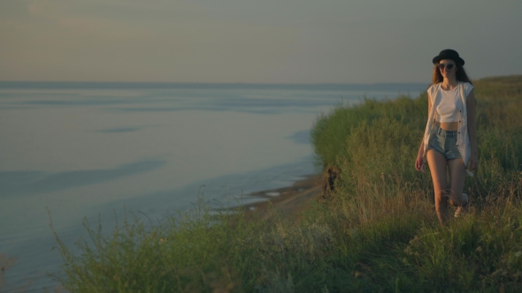 Young Woman In Walk On The Edge Of a Cliff Enjoying The Nature