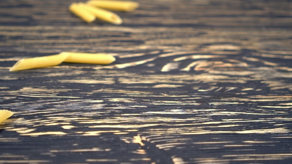 Pasta Falling on the Wooden Background