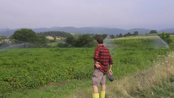 The farmer takes off his hat and wipes his sweat. alt