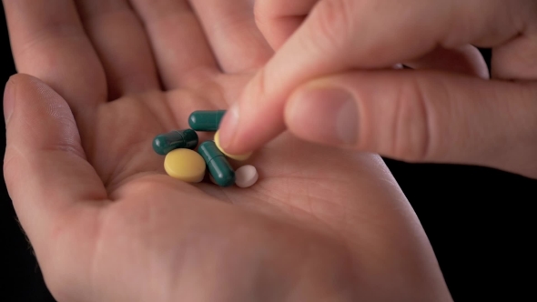 The Young Doctor With a Hand Full Of Pills. A Lot Of Drugs In Man Hand. alt