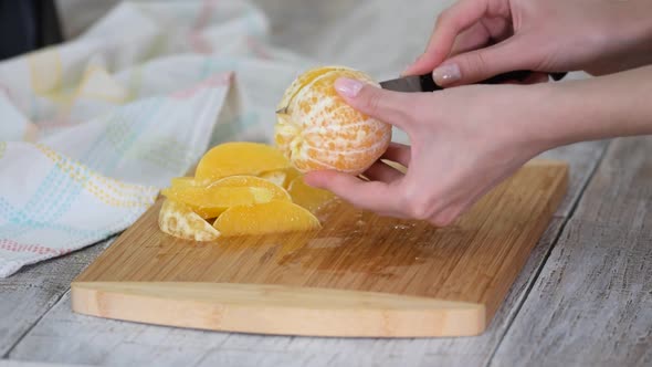 Closeup Hand Slicing a Orange Fruit