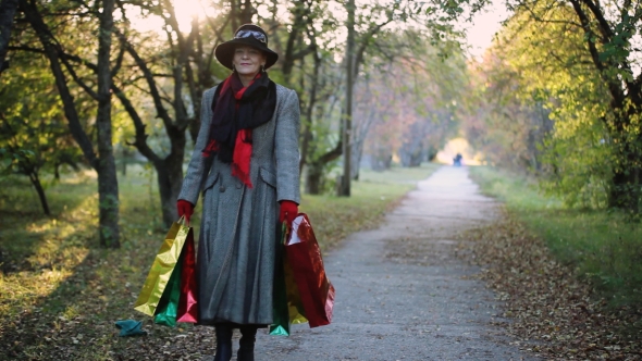 Mature Elegant Woman In Age Wearing Hat And Coat Holding Colorful Shopping Bags, Autumn Concept
