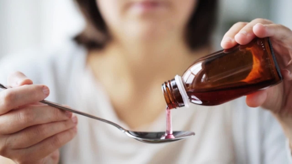 Woman Pouring Medication To Spoon alt
