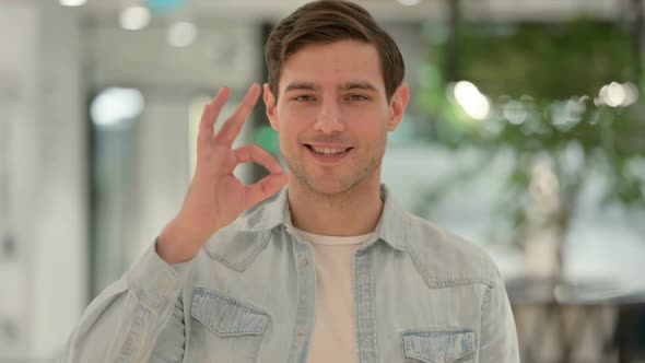 Portrait of Creative Young Man Showing Okay Sign with Hand alt