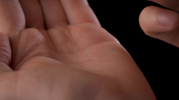 Man's Hand Taking Out Pills From Blister Pack Isolated On Black alt