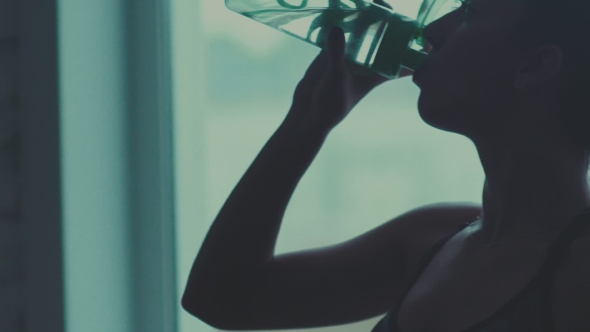 Silhouette Of a Woman With a Bottle Of Water.