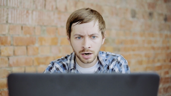 Hard Working Young Man In Front Of Laptop In Office.