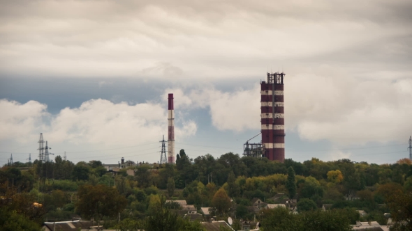 Clouds Moving Over The Pipe Plant And Buildings.