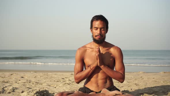 A Man Does Yoga and Meditation in the Lotus Position in Nature alt