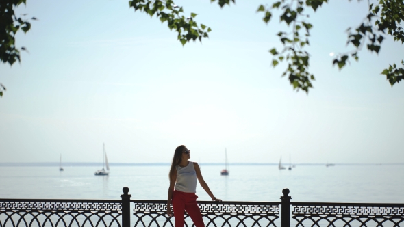 Woman At The Pier Near Yacht On The Background Of Blue Sky