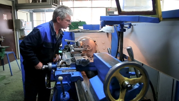 Worker Operating In Manual Lathe