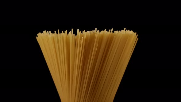 Raw spaghetti rotating on black background