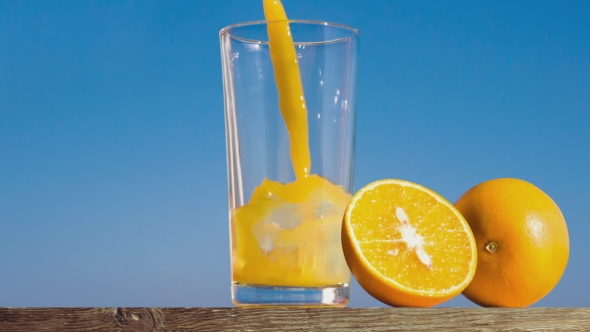 Pouring a Glass Of Orange Juice Creating Splash
