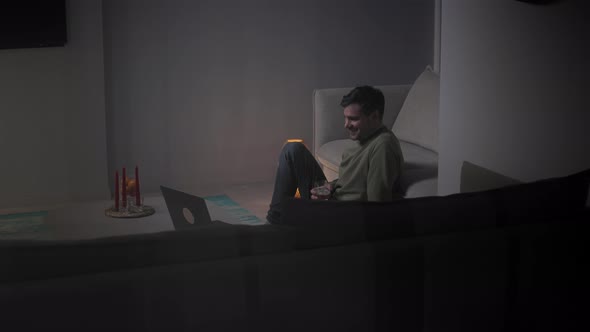 Young adult man using laptop in the living room