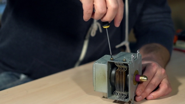 Man Repairing Broken Device In Workshop