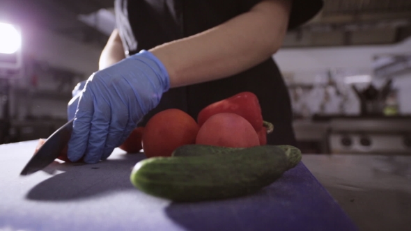 Hands Of Chef in Gloves Slicing up a Tomato with a Knife on Cutting ...