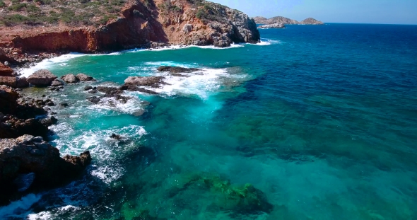 Blue Sea, Waves Breaking In Cliffs At Shore