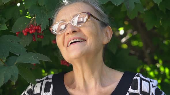 Beautiful Old Grandmother with Grey Hair and Face with Wrinkles Wearing Eyeglasses is Grimacing and alt