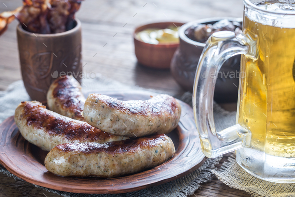 Grilled sausages with fried bacon rashers and mushrooms