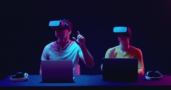 Man and woman wearing VR headsets alt