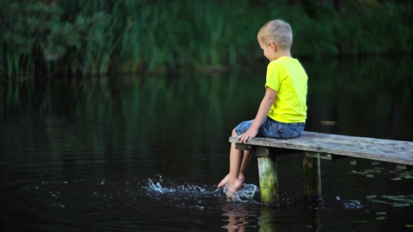 Boy Sitting On Bridge At Pool