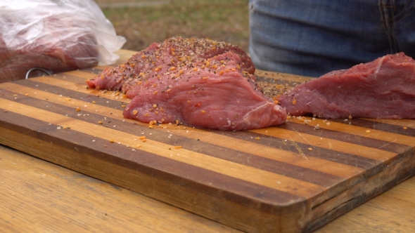 Man Preparing Meat For Barbeque