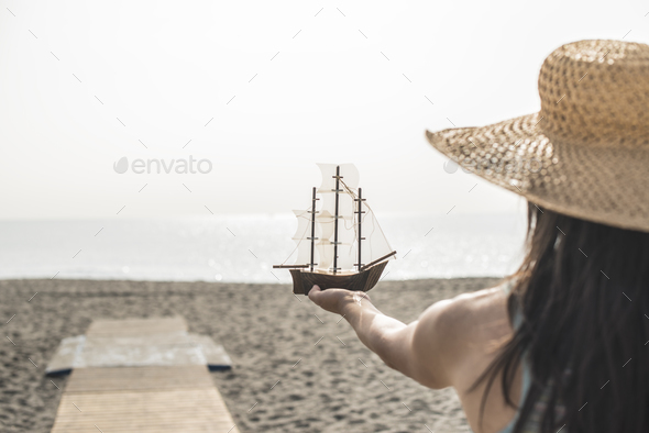 Woman hold boat model on the beach