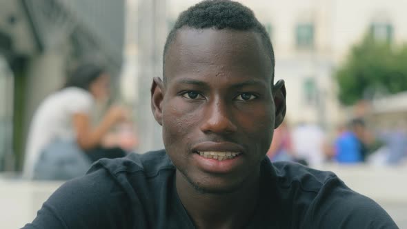 attractive young american african man smiling at camera- portrait alt