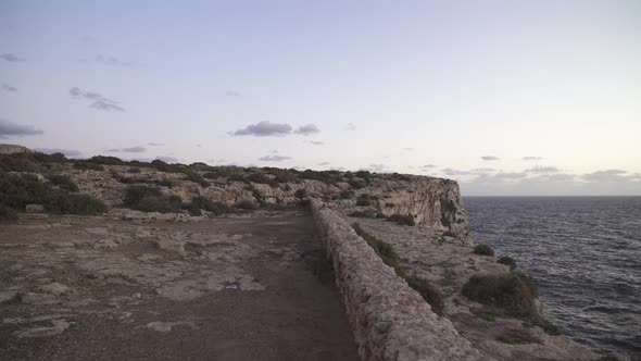 Walking on Plateu Towards Rocky Hill near Mediterranean Sea in Malta on Purple Colour Sunny Evening