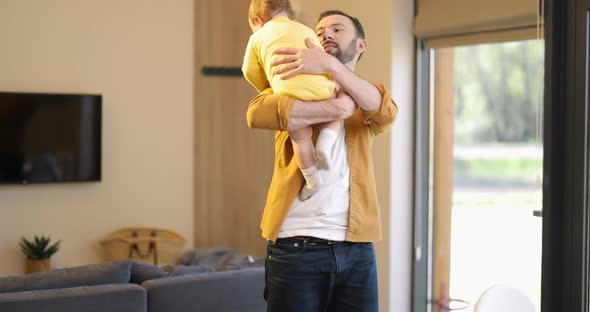 Father Nursing His Baby Son and Works From Home alt