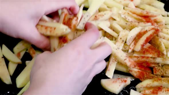 Mix spices with long raw fries potatoes by hands