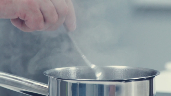 The Chef Mixes The Contents Of The Pan Using Tablespoon.