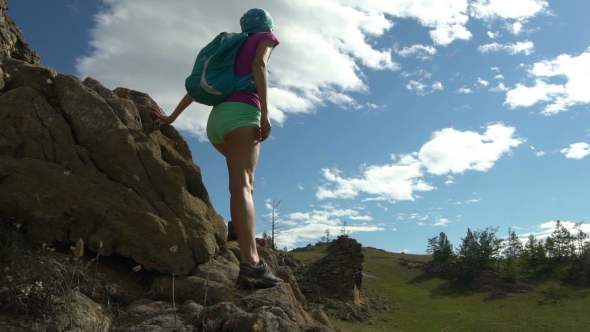 Young Woman Climbing To The Mountain