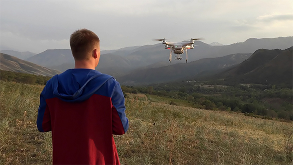 A Man with a Drone in the Mountains